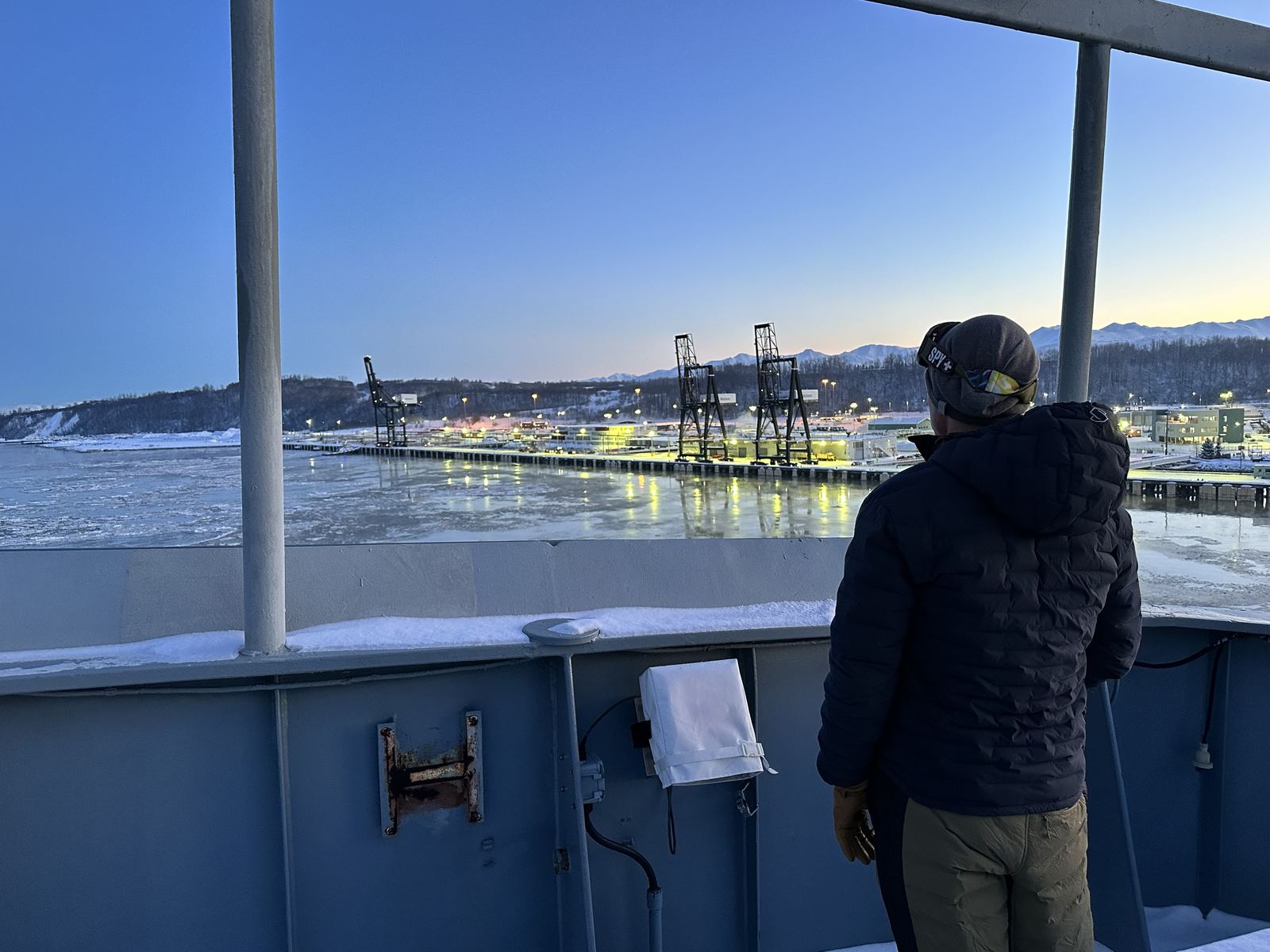 A pilot on a snow-covered bridge wing above the ice at the Port of Alaska