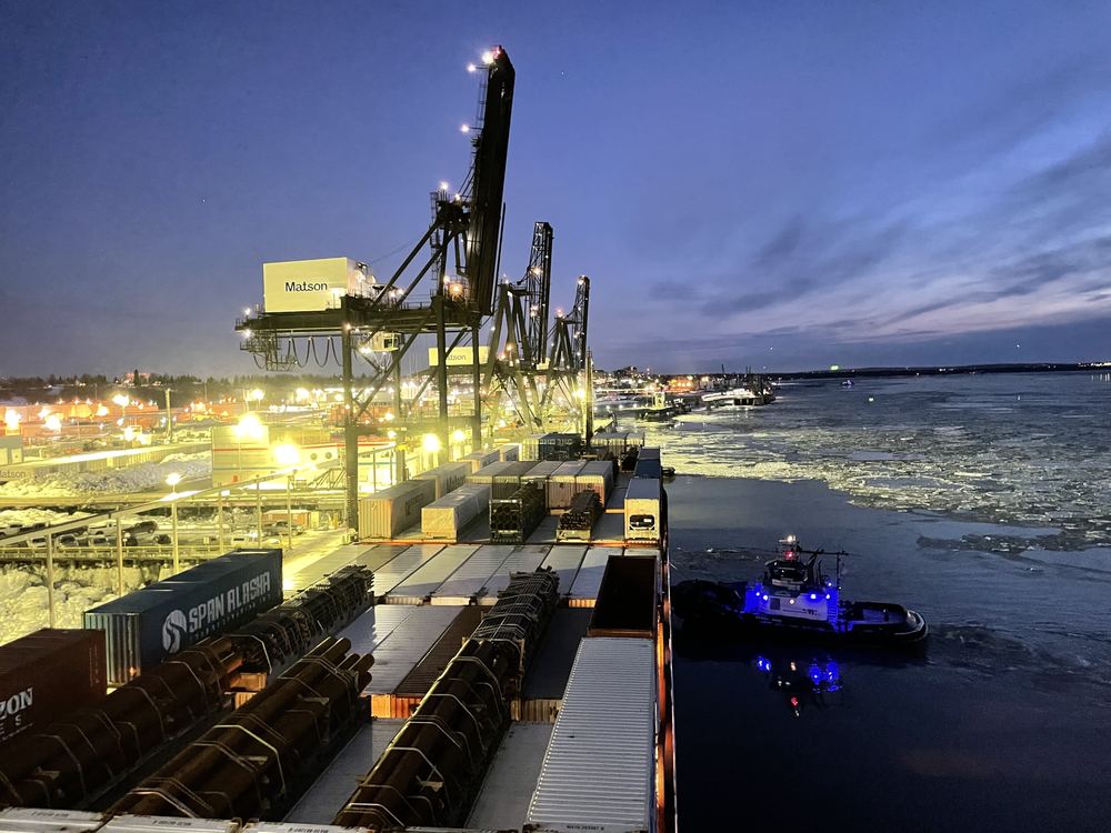 A tug and a container crane at dusk at the Port of Alaska