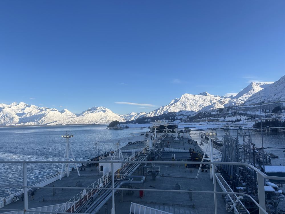 Snow-covered mountains ahead of a tanker's deck