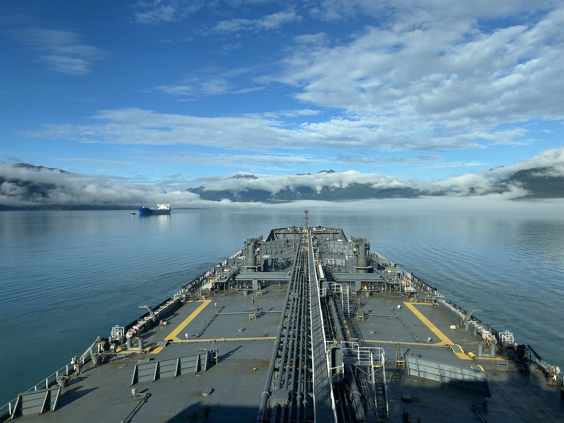 Looking over a tanker's bow down Valdez Arm, with low cloud on the mountains