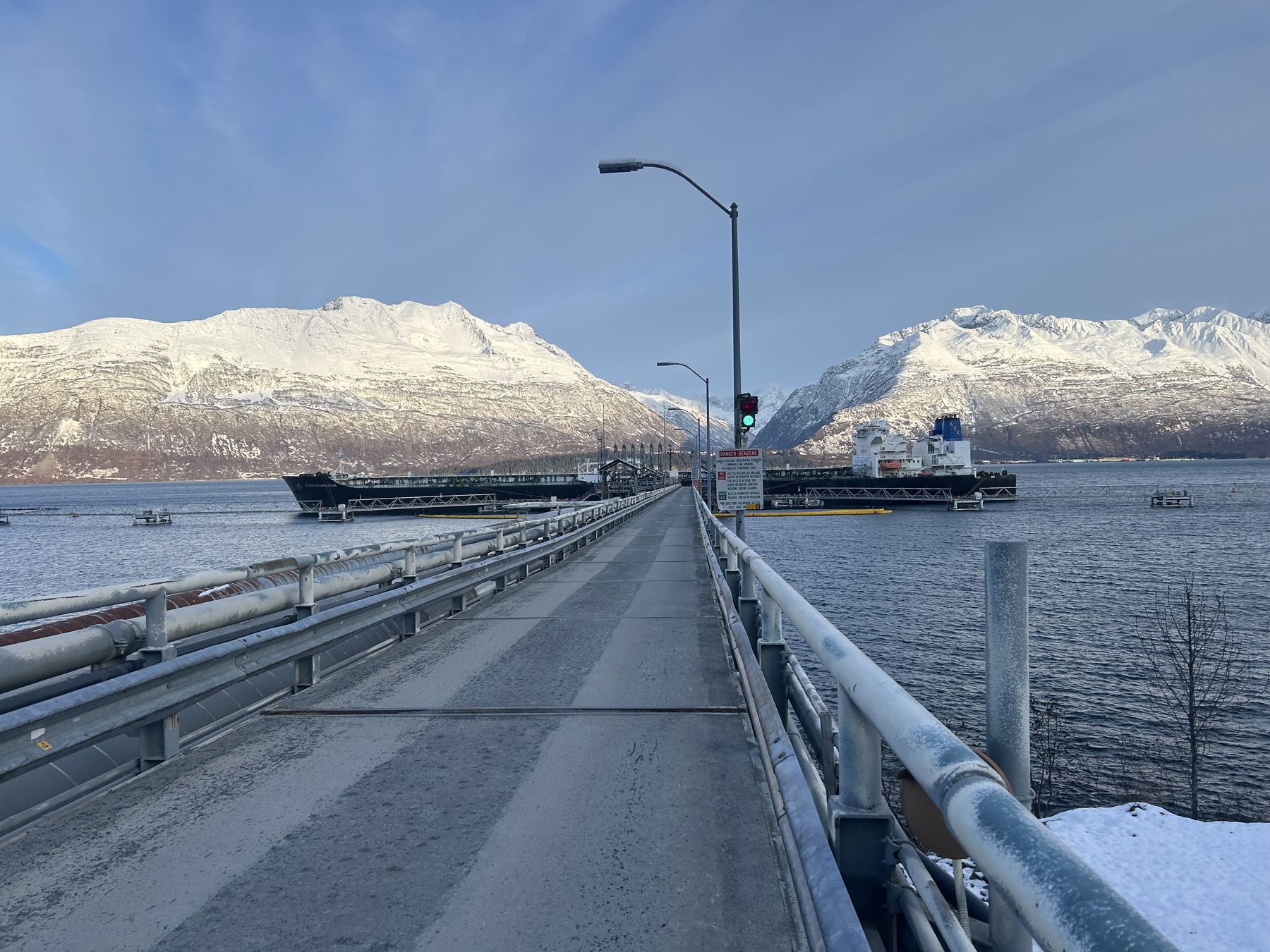 The pier at the Valdez Marine Terminal, with tankers at the berths below snow-covered mountains